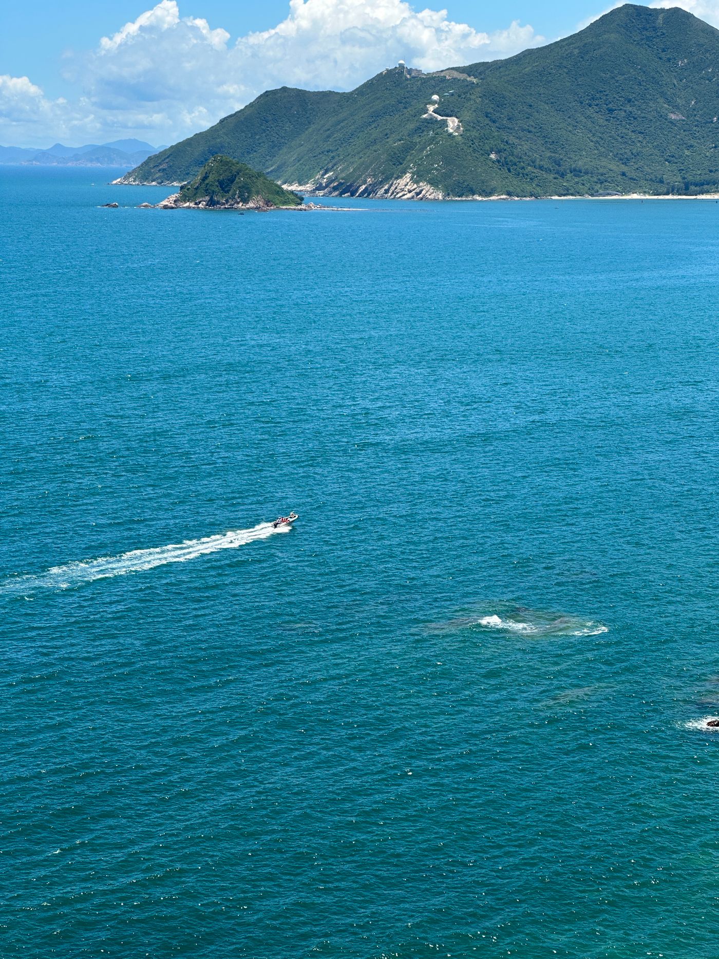 Vue aérienne d’un bateau à moteur près d’une côte, photographie illustrative