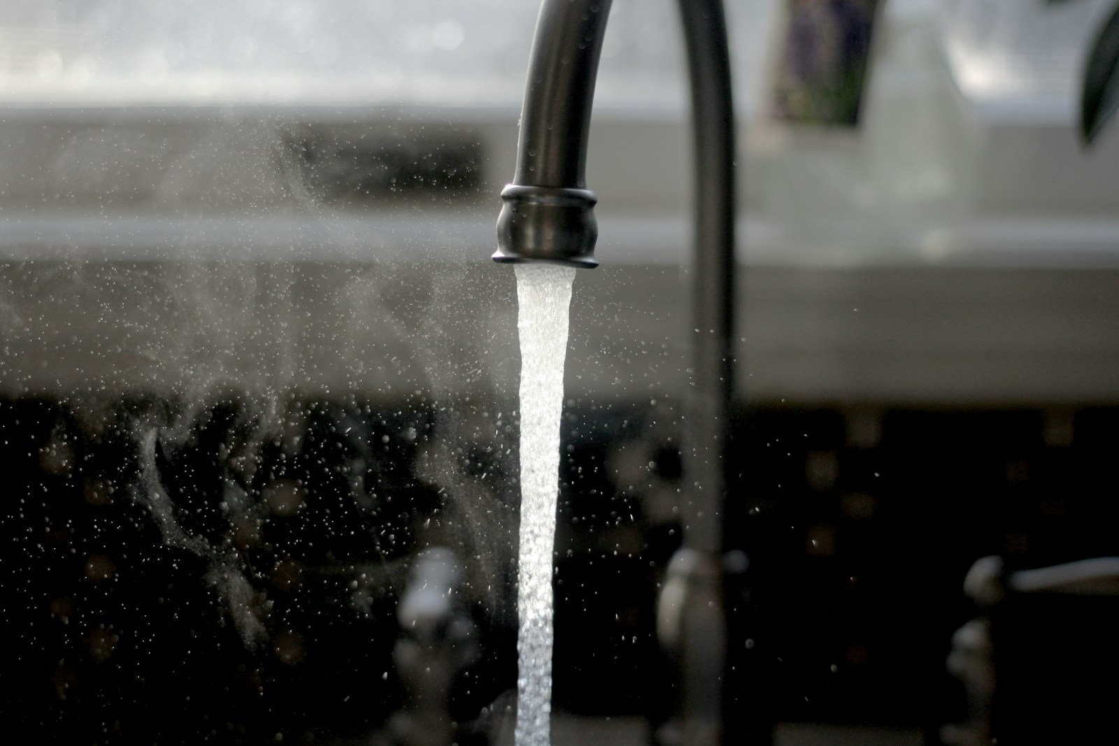 Robinet métallique et eau coulant dans un évier