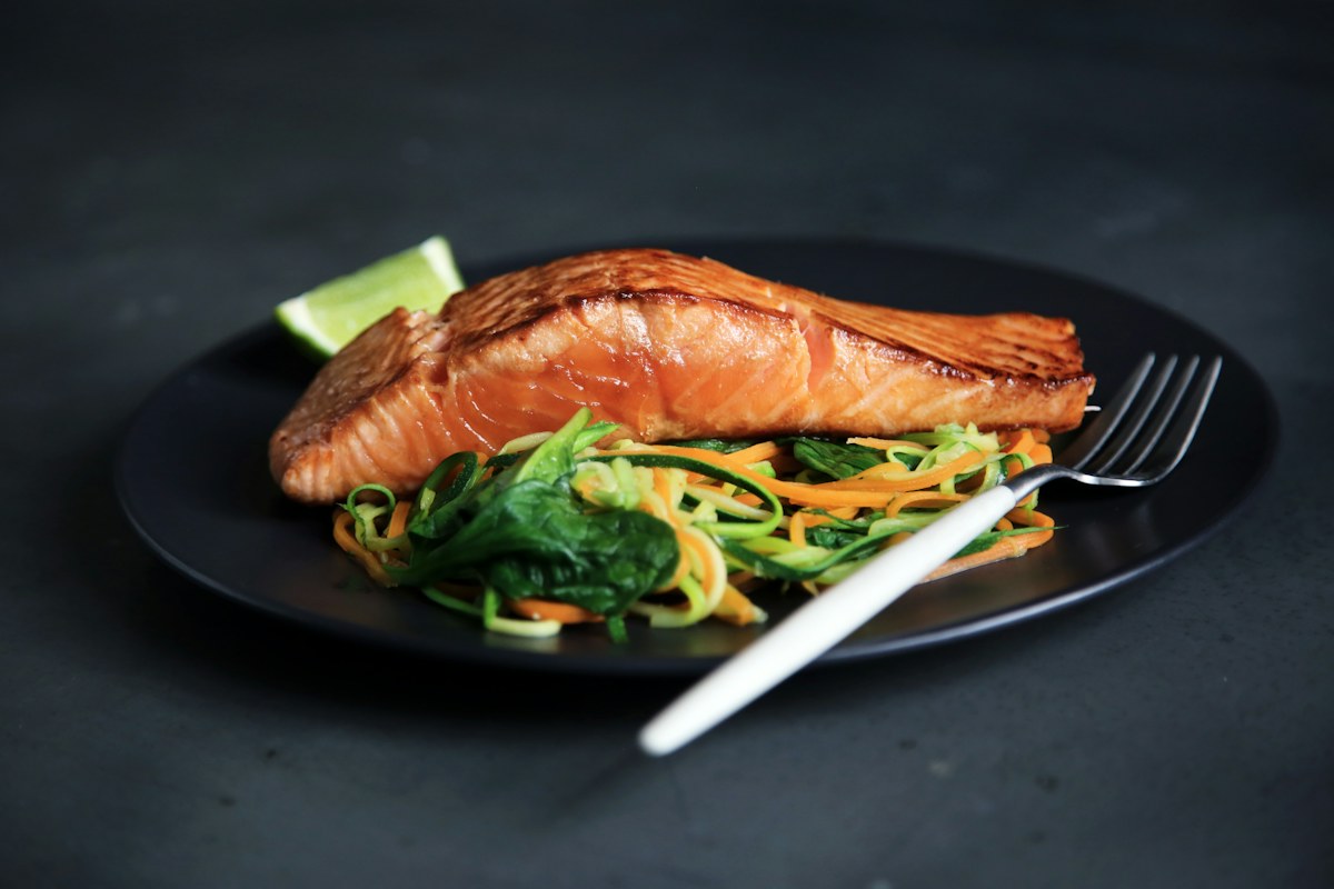 Poisson rôti, légumes et citron servis dans une assiette