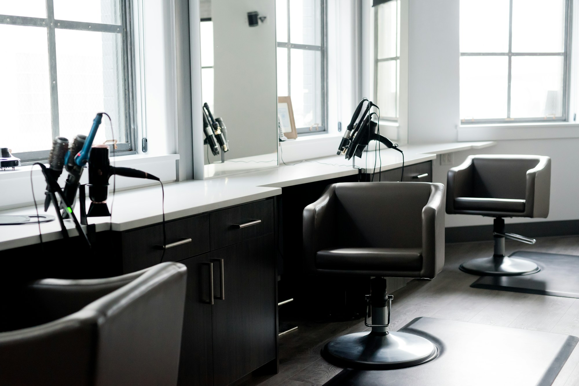 Fauteuils de coiffure et miroirs baignés de lumière naturelle